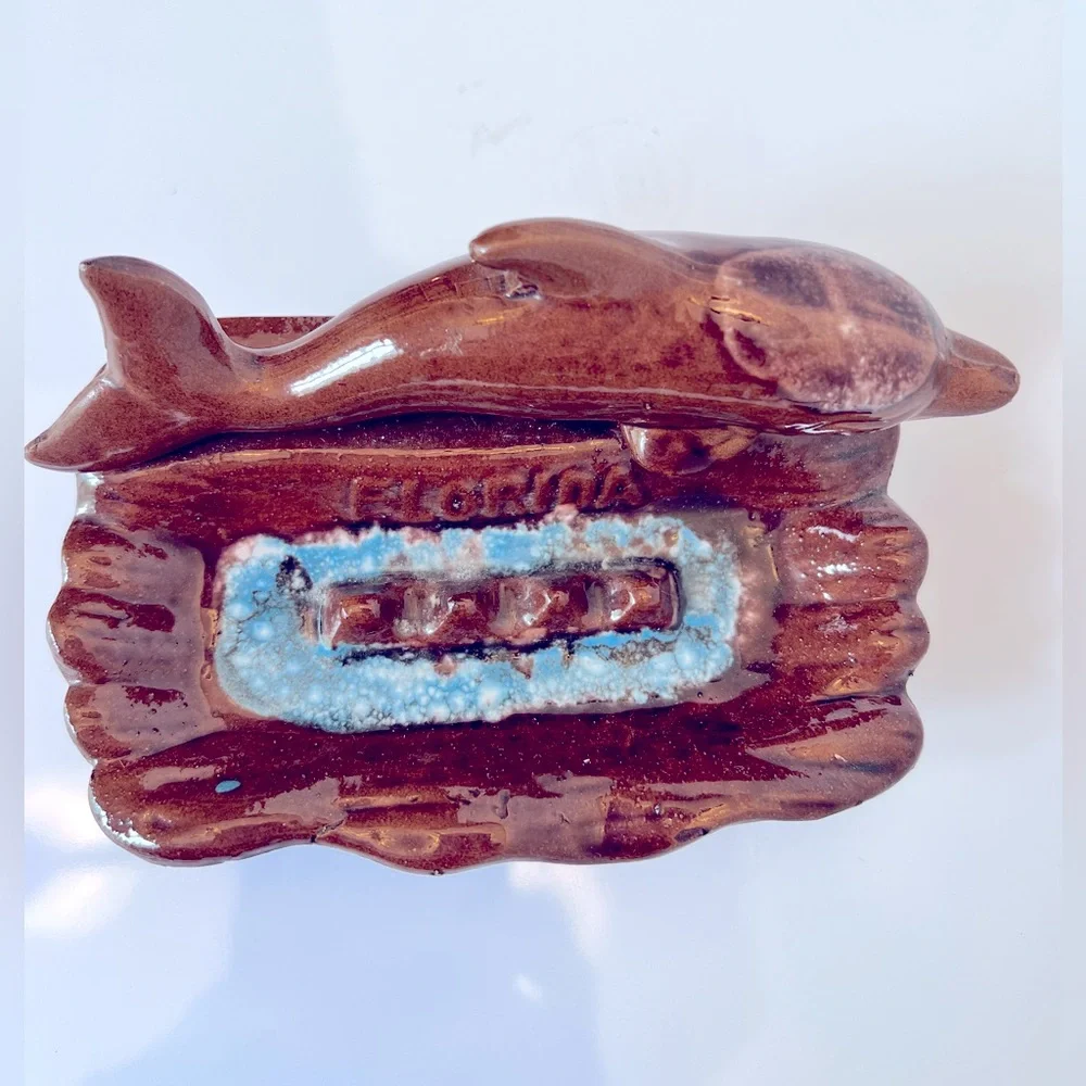 Vintage Ceramic Florida Ashtray with a Brown Dolphin Swimming in Blue Water.